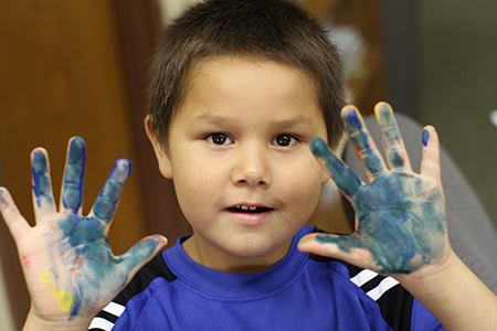 Boy with finger paint on his hands